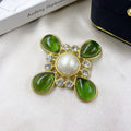 Close-up of a zinc alloy baroque brooch with a central crystal cross in a vintage style.