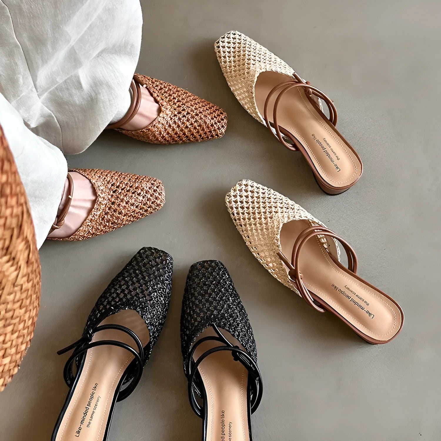Women's black square toe slippers with chunky heel and breathable hollow-out design on a wooden floor