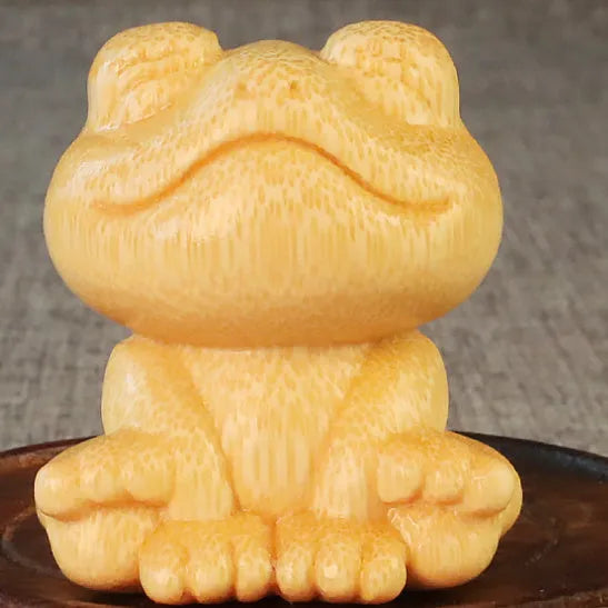 Solid bamboo carving ornament of a smiling cartoon frog, 5 cm tall.