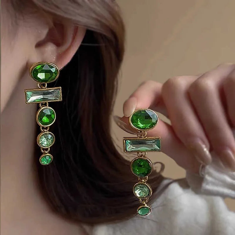 Close-up of green gradient geometric alloy earrings with long tassels and sparkling inlaid zircons.