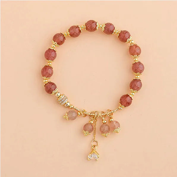 Pink women's bracelet with heart-shaped strawberry quartz crystals and pearl bead accents on adjustable band