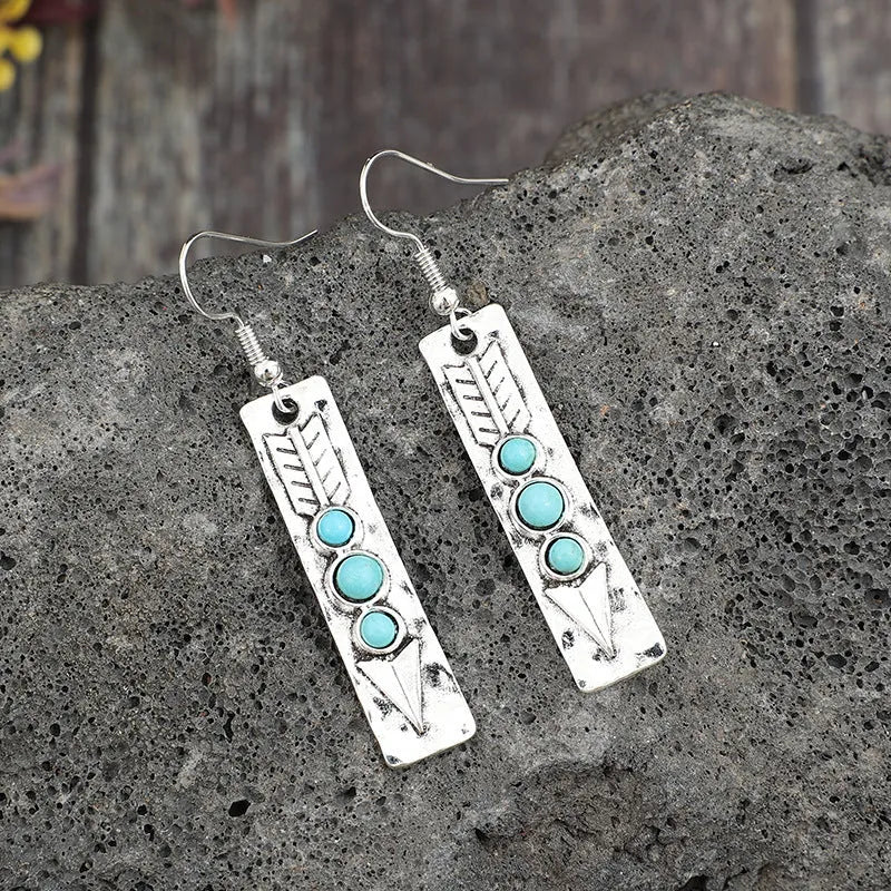Silver geometric drop earrings with turquoise coloured inlays showing retro styling