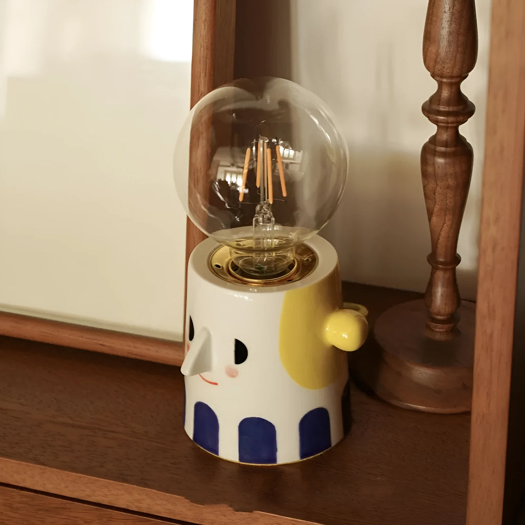 Handmade ceramic bedside lamp with ball-shaped headlight design on wooden surface