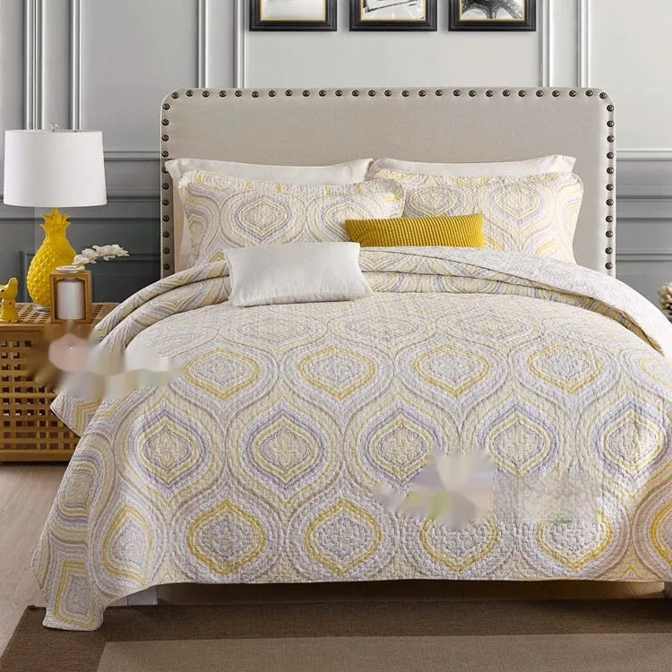 Quilted cotton bed cover set with printed pattern on bed with matching pillowcases