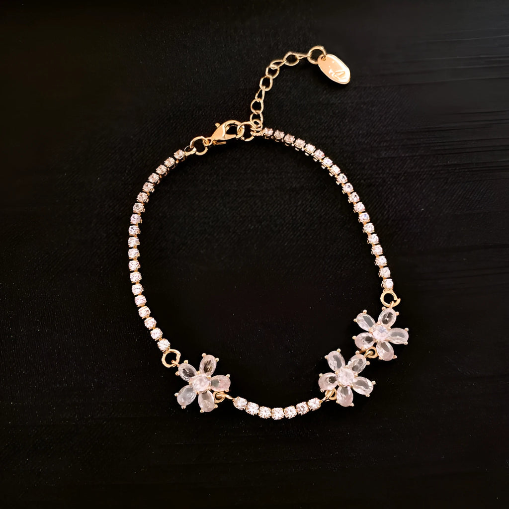 Gold-toned copper geometric bracelet with quadrilateral design and zircon stone accents