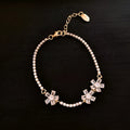 Gold-toned copper geometric bracelet with quadrilateral design and zircon stone accents