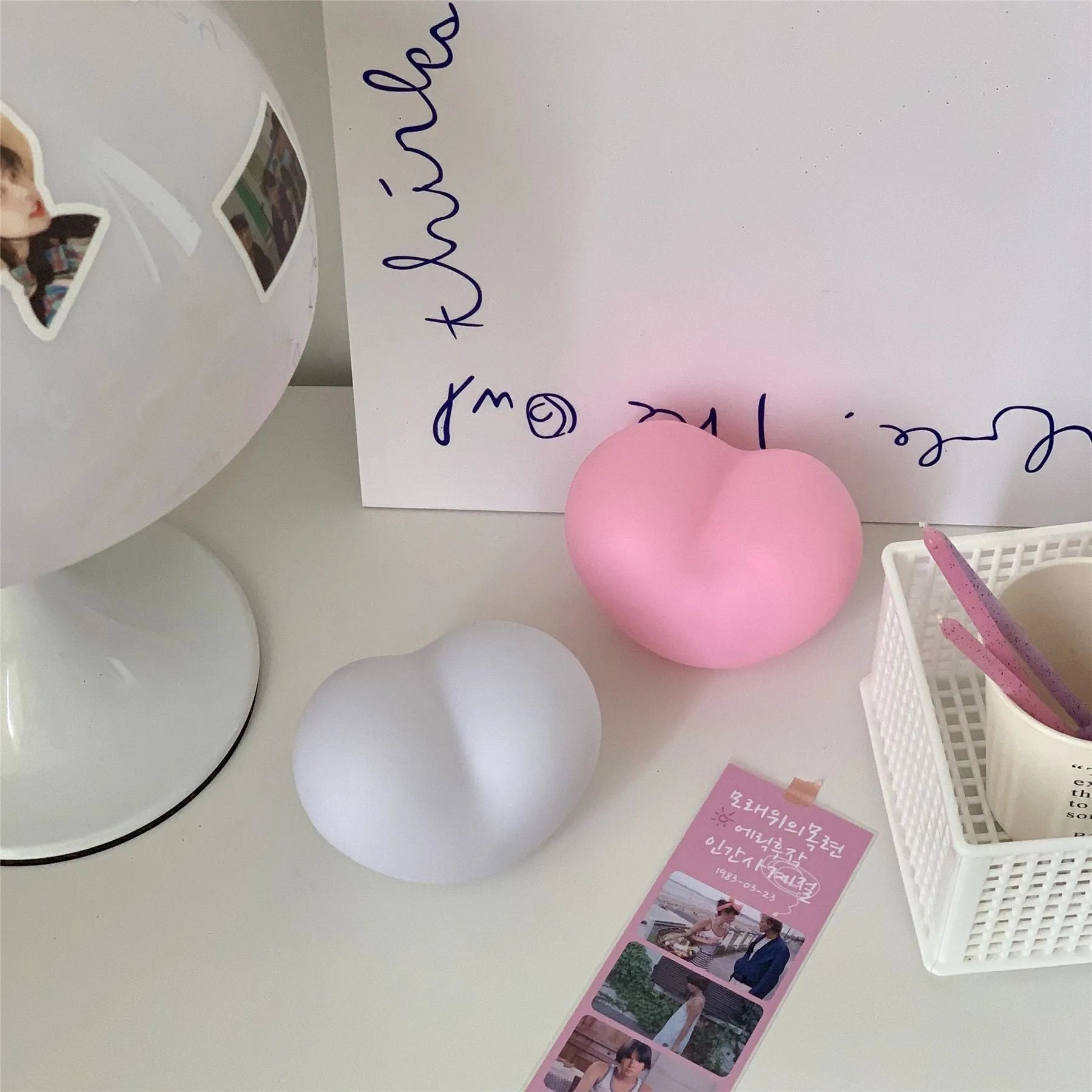 White and pink vinyl trumpet-shaped atmosphere lamps glowing with warm light on a dark surface.
