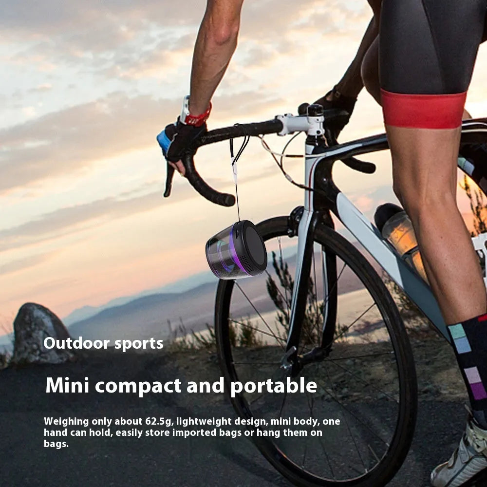 Compact black or white portable Bluetooth speaker with magnetic base and built-in ambience lighting.