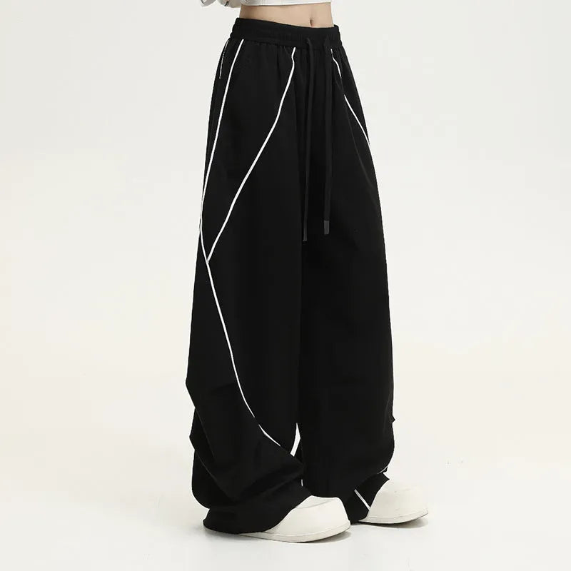 Black striped pleated hip hop trousers with wide-leg design shown flat