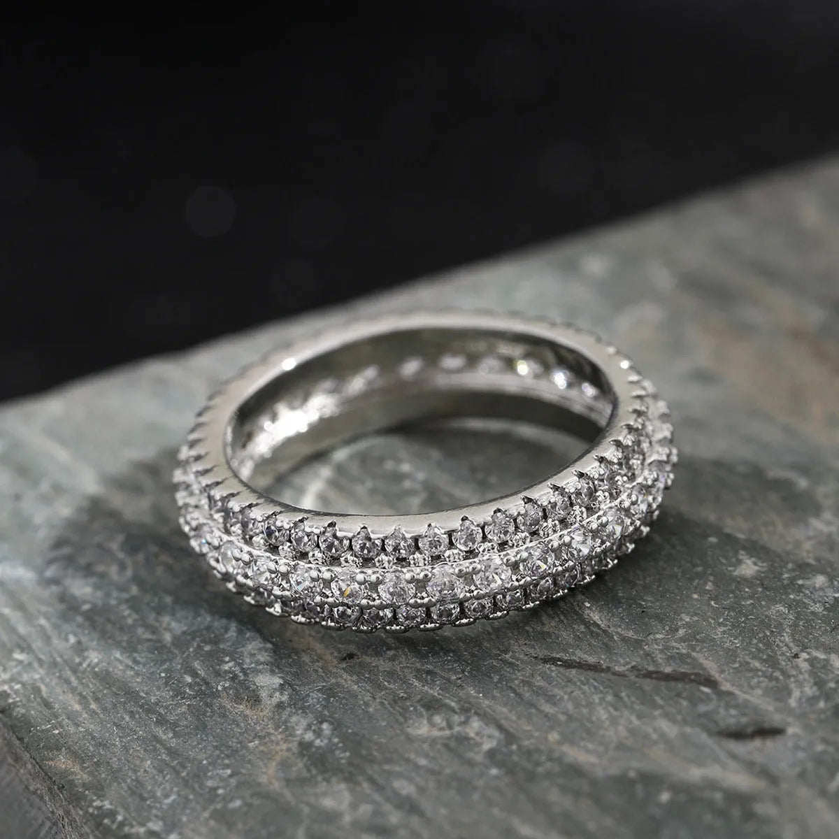 Geometric triangular unisex ring with a central zircon stone, shown in white gold, yellow gold, and white and black plating options.