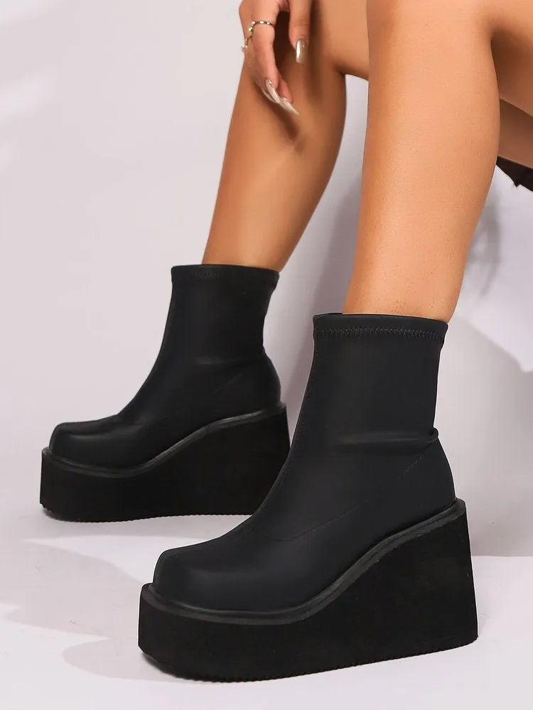 Plus size women's black wedge heel boots with a waterproof platform on a white background.