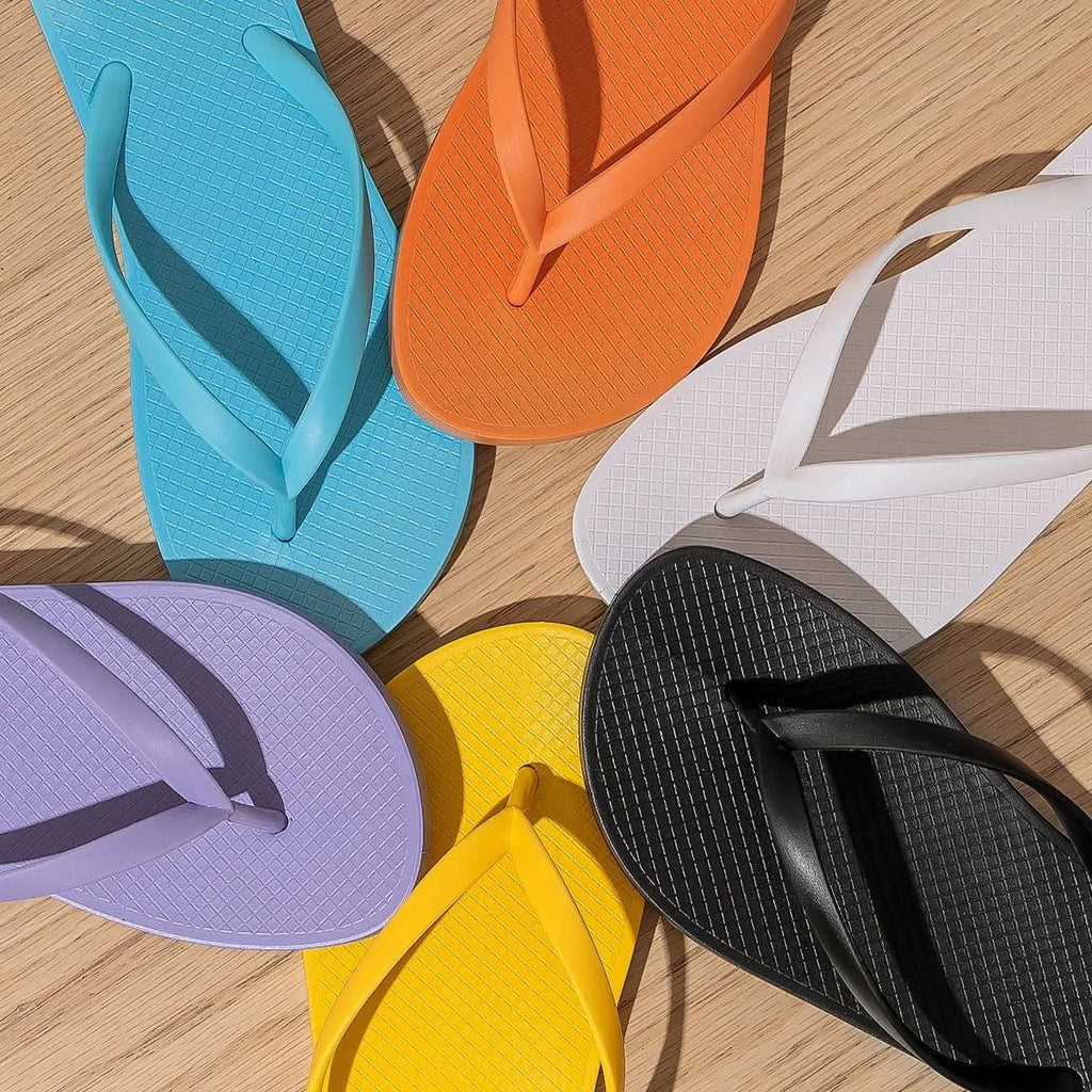 Orange foldable beach slippers showing hollow-out plastic upper and non-slip PVC sole