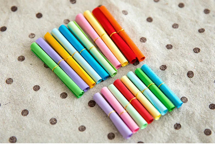 Colourful assortment of small rolled paper scrolls with central holes for drift bottle messages