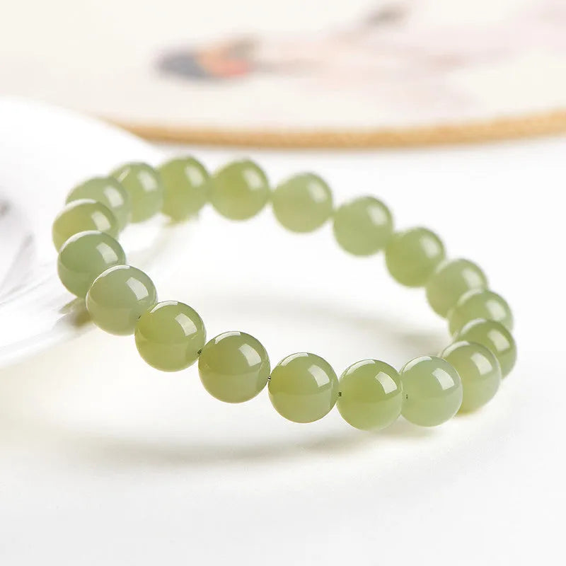 Polished Hetian jade bead bracelet in ice clear colour on a wrist, showing bead detail.
