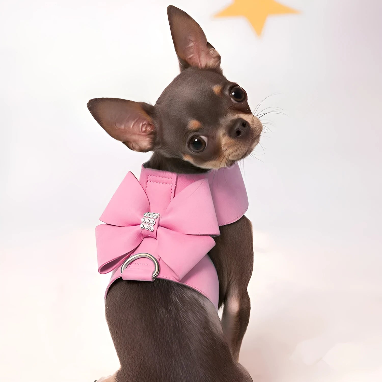 A pink microfiber puppy chest strap harness with a large bowknot, shown on a small dog.