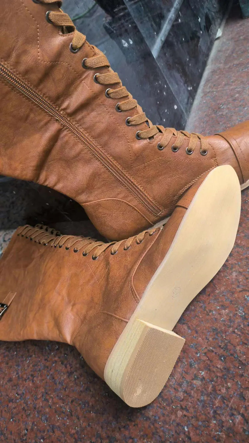 Women's black cross strap knight boots made from artificial PU, showing front strap detail.