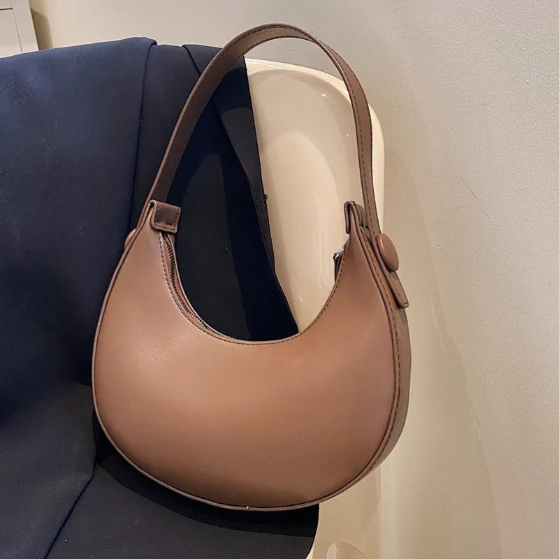 Women's retro PU leather shoulder bag in dumpling shape with zipper pocket, showing cream yellow colour option