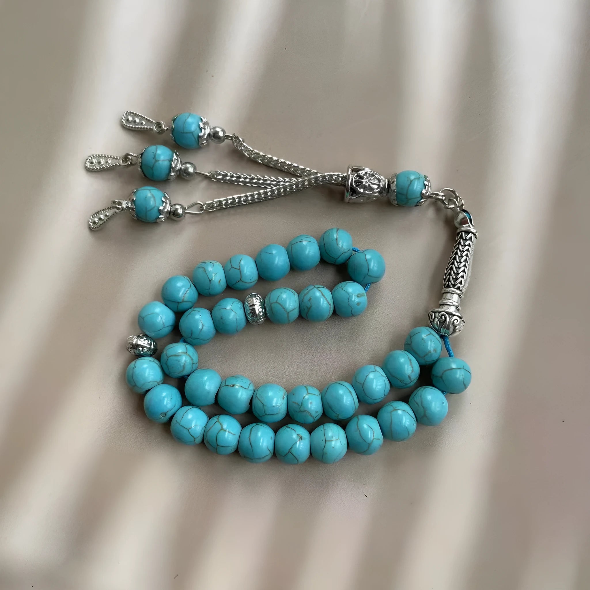 Sky blue stone bead Muslim prayer bracelet on wrist, handmade with elasticated cord.