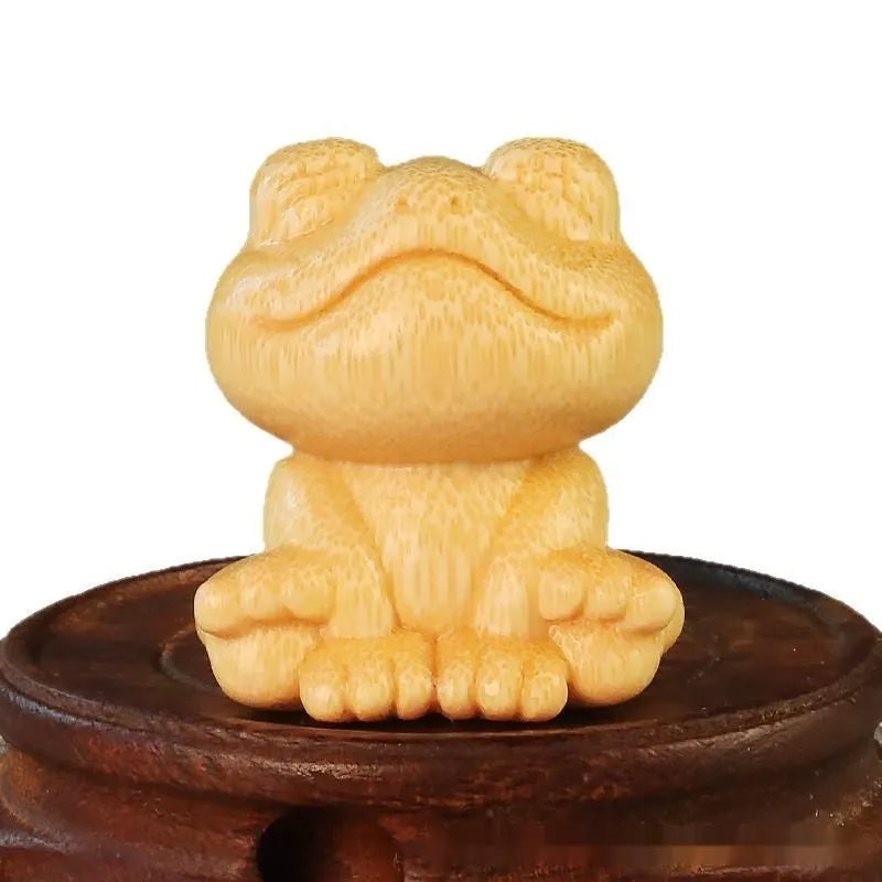 Solid bamboo carving ornament of a smiling cartoon frog, 5 cm tall.