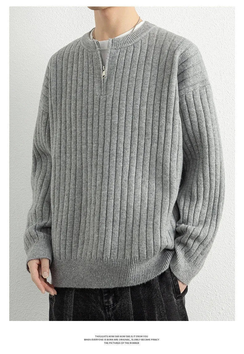 Man wearing a grey textured knit half zip sweater with a loose fit and long sleeves.
