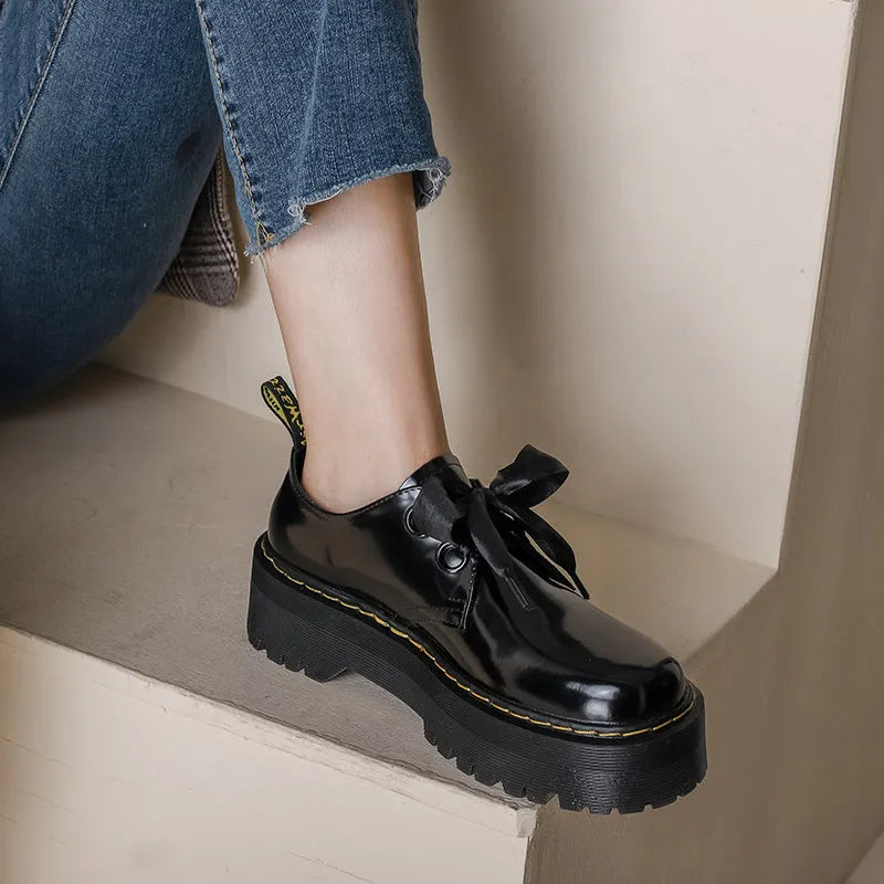 Women's black lace-up shoes with thick TPR sole, ribbon and cross strap details on superfine fibre upper.