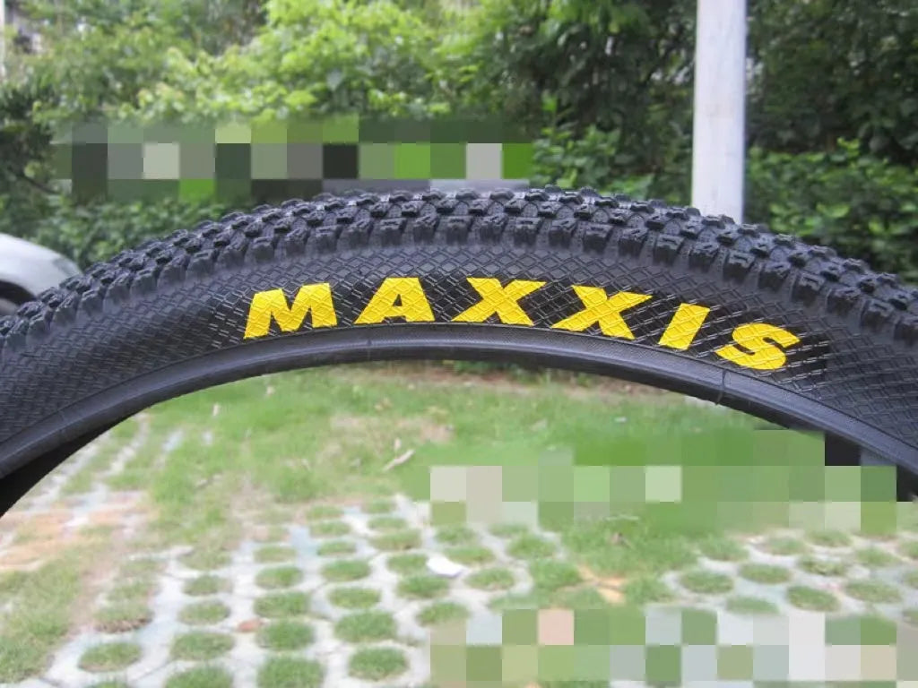 Ultralight black mountain bike tyre with white label sidewall option on a trail.