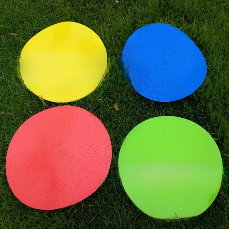 Soft TPE football training marker disc in yellow, 23 cm diameter, lying flat on grass.