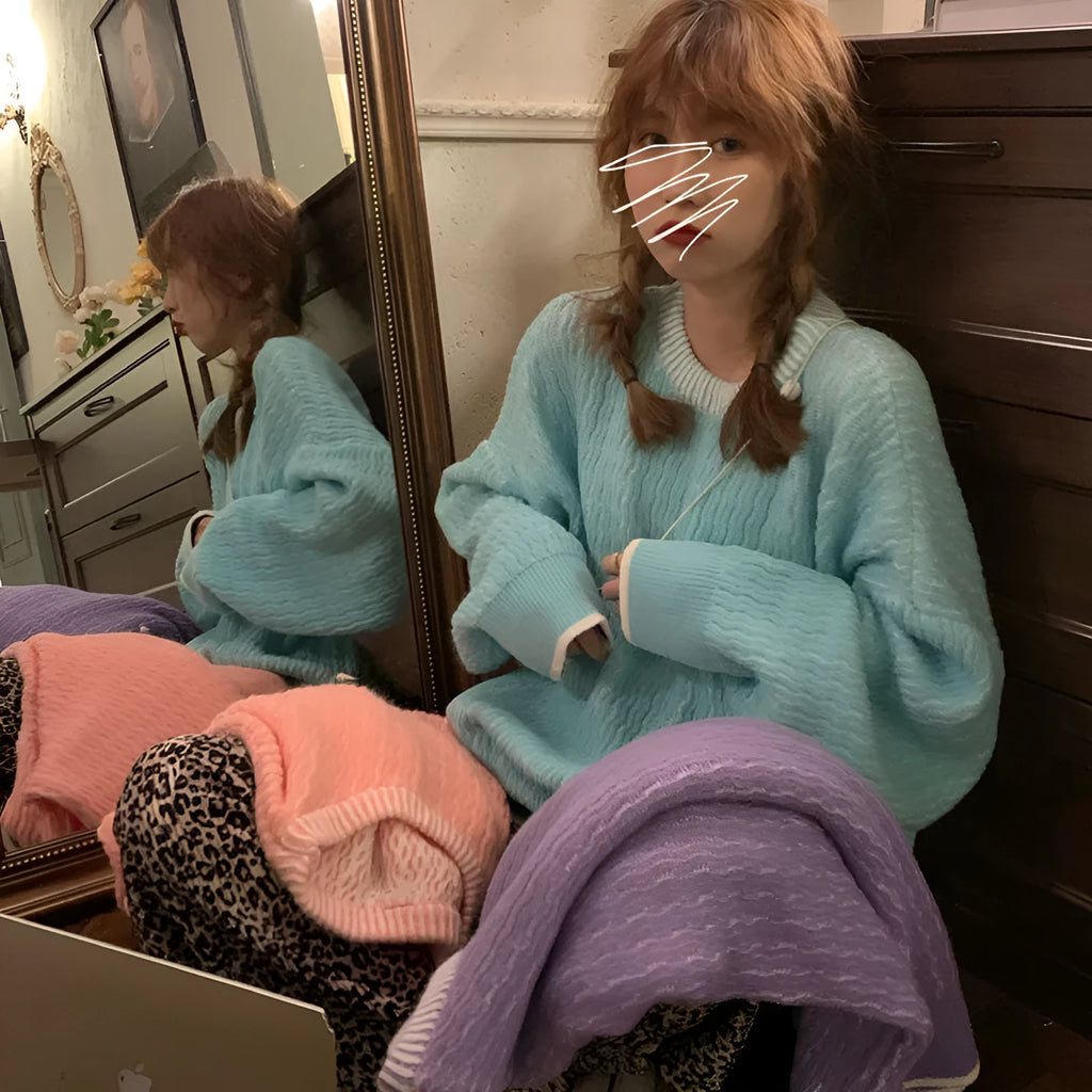 Women's loose blue pullover sweater with regular sleeves on a hanger.