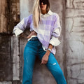 Loose lilac plaid print sweater with ribbed trim on a hanger