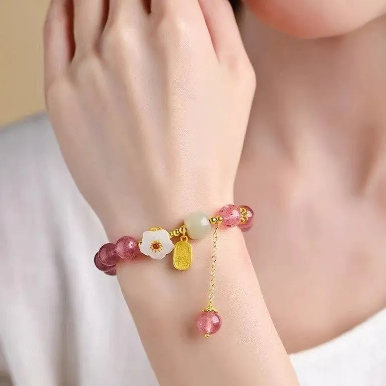 Handcrafted strawberry quartz and Hetian jade bracelet with peach blossom charm for girls.