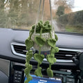 Green and white hand-knitted car plant ornament with a hanging cord on a basin-shaped base.