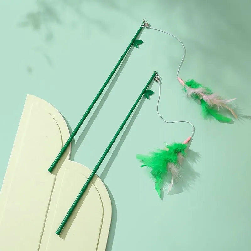 Green interactive cat wand toy with feathers and a bell on a durable plastic handle.