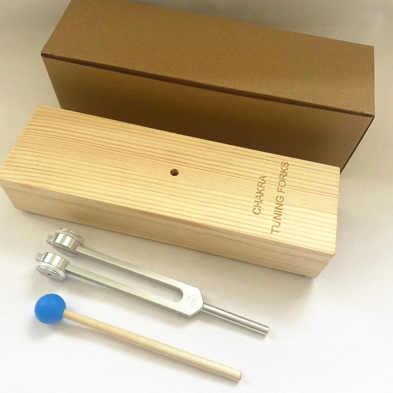 432Hz aluminium tuning fork and small speaker set on kraft paper packaging