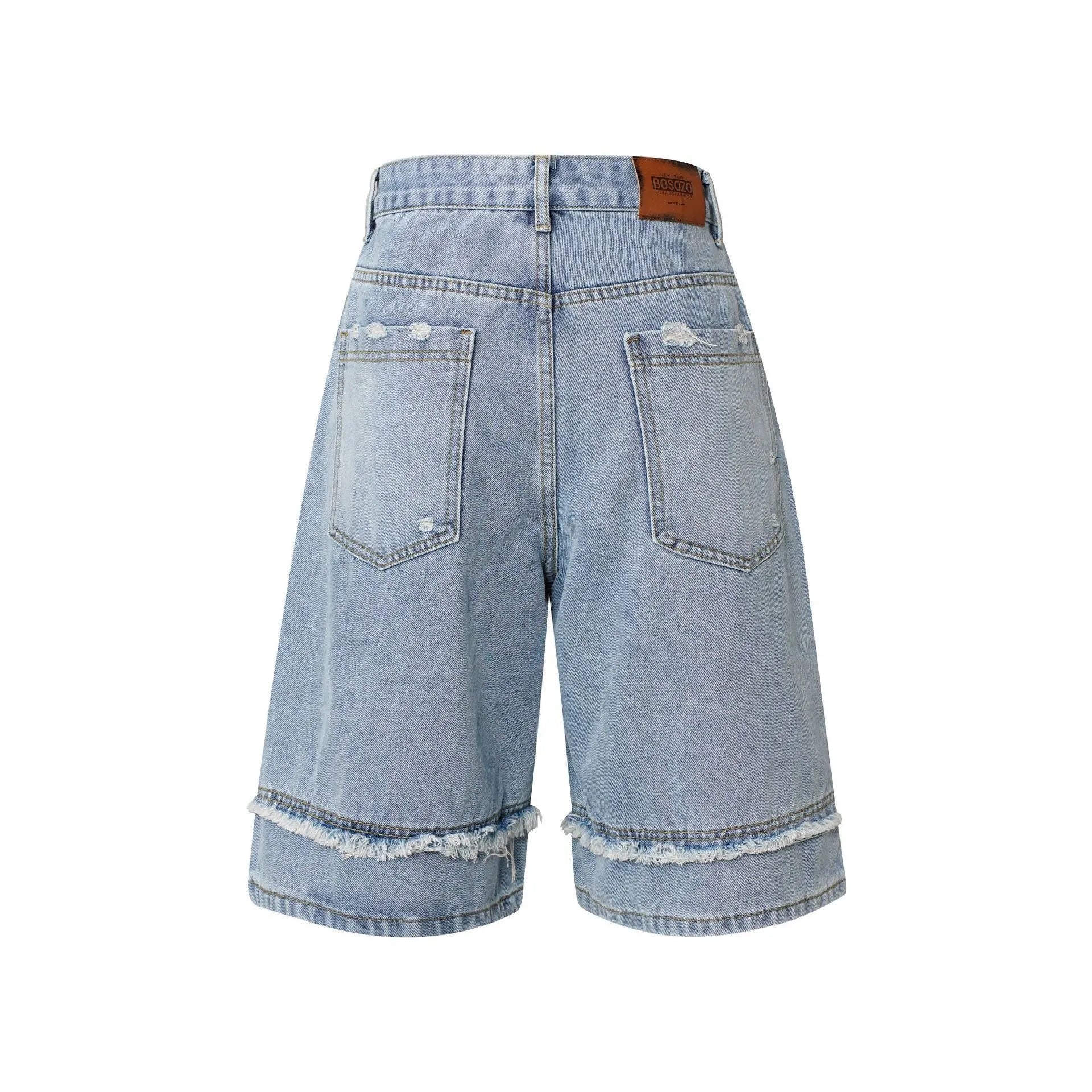 Straight cut denim shorts with raw edge distressing in black, shown on a model.