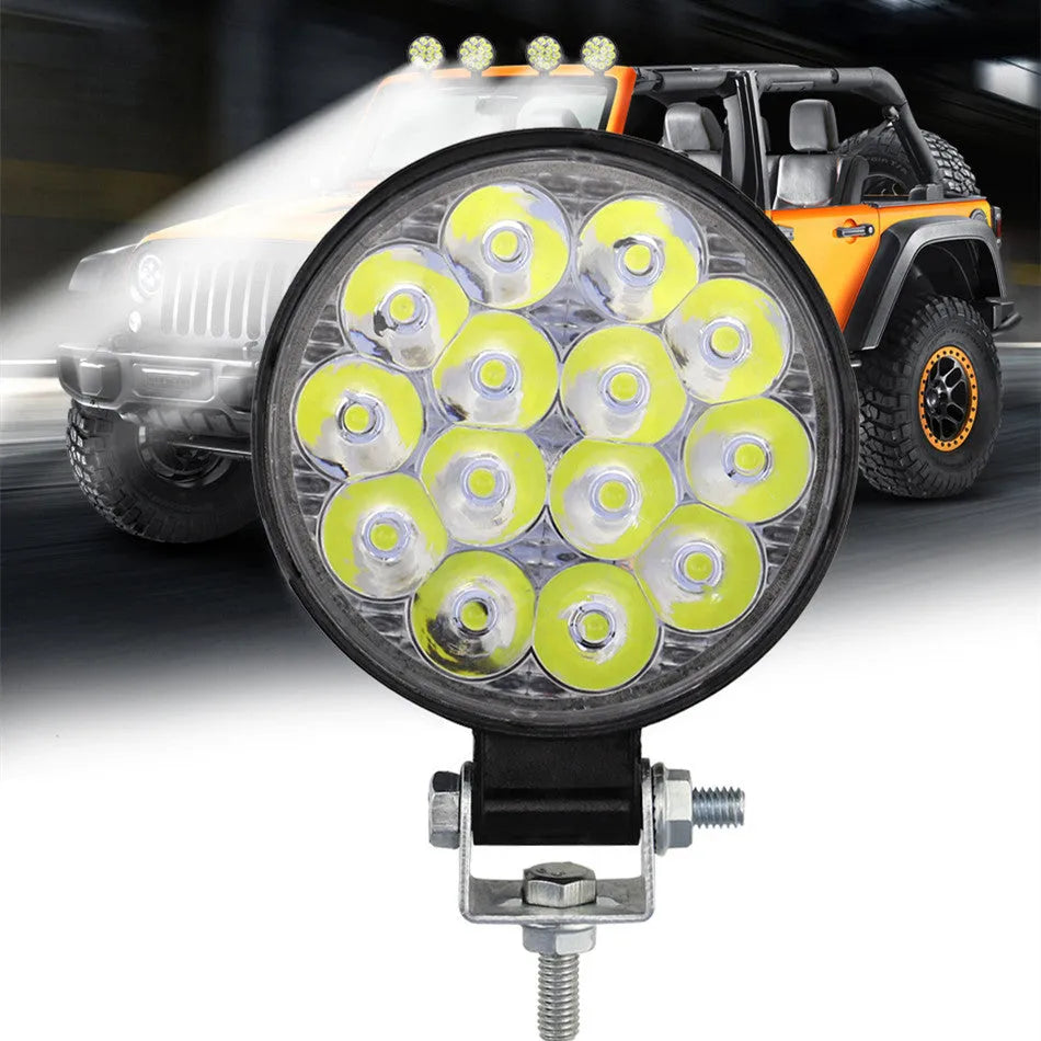 Compact round white LED work light with aluminium housing, suitable for mounting on a vehicle.