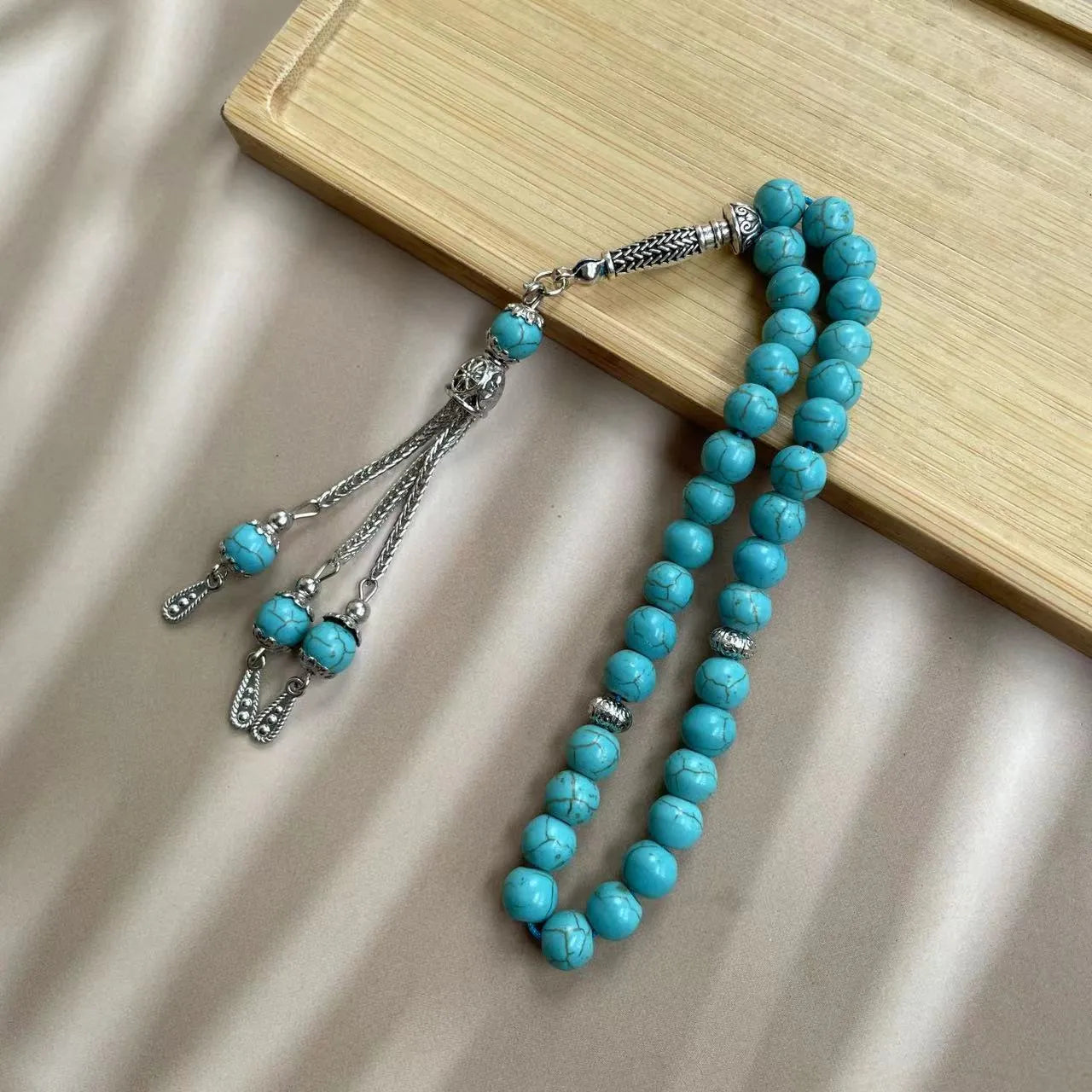 Sky blue stone bead Muslim prayer bracelet on wrist, handmade with elasticated cord.