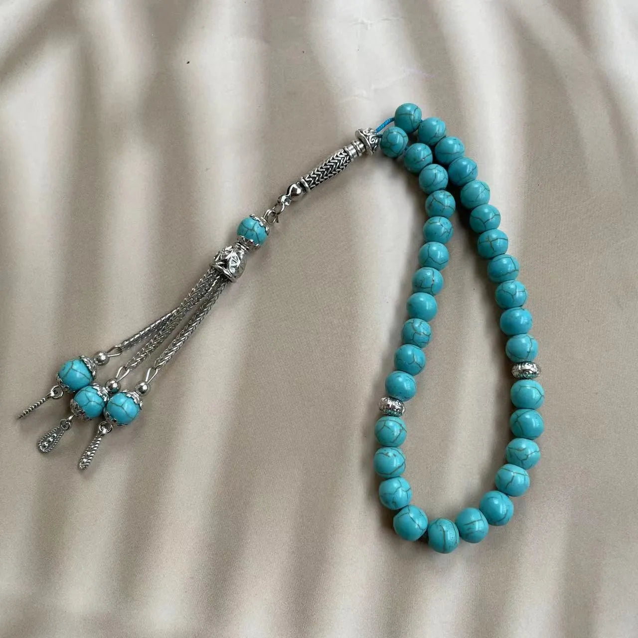 Sky blue stone bead Muslim prayer bracelet on wrist, handmade with elasticated cord.