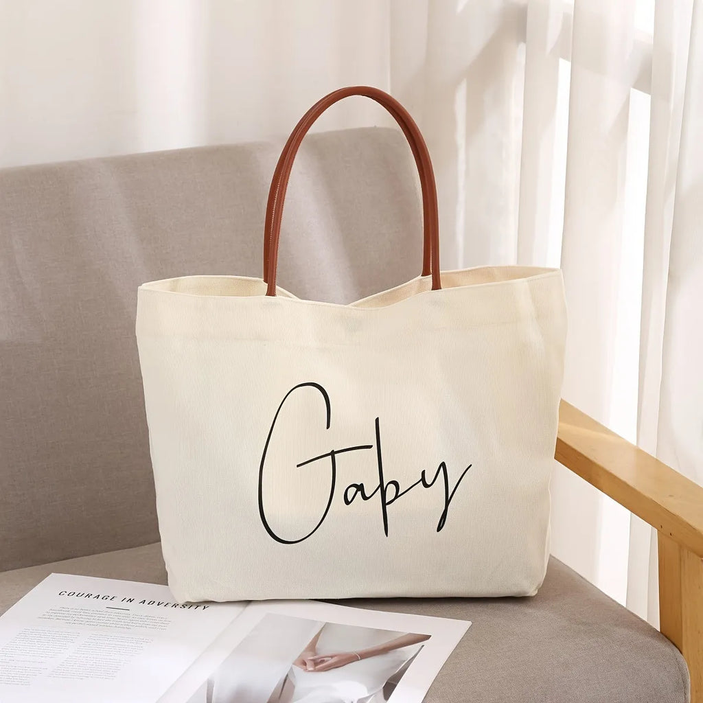 Beige white cotton canvas tote bag with sturdy handles on a plain background.