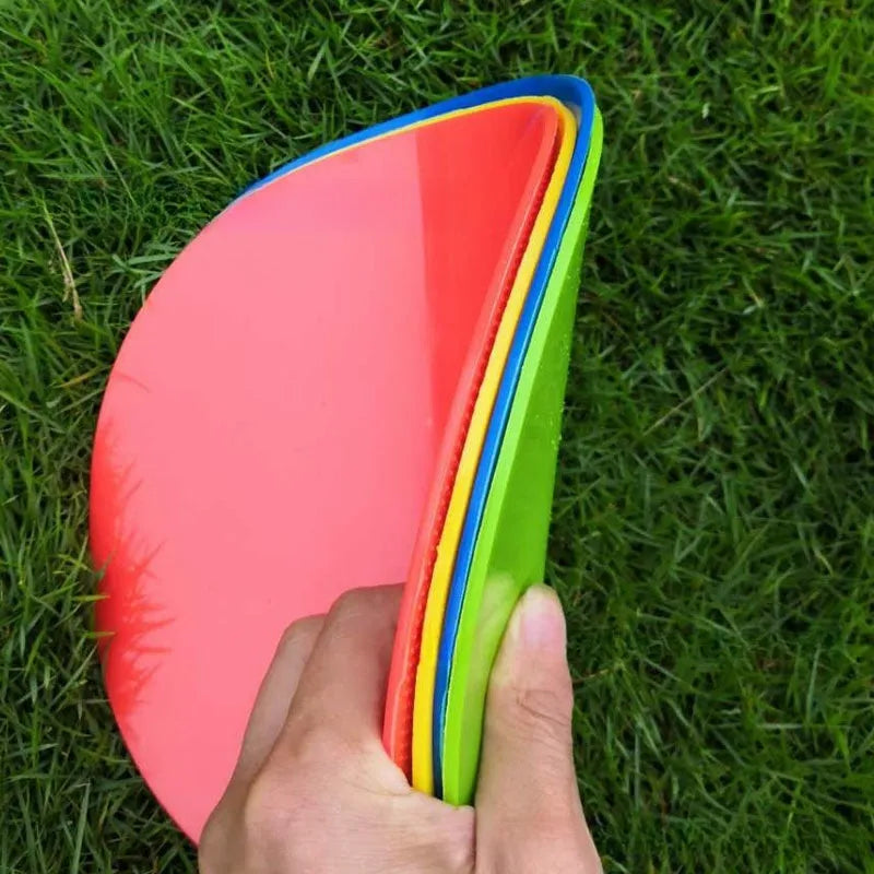 Soft TPE football training marker disc in yellow, 23 cm diameter, lying flat on grass.