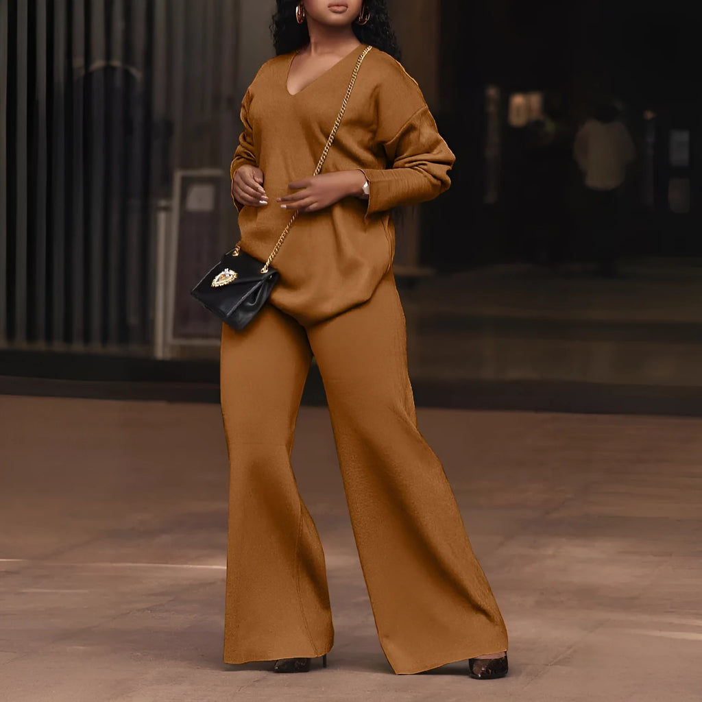 Women's brown suede two-piece suit with long sleeves and trousers on a hanger