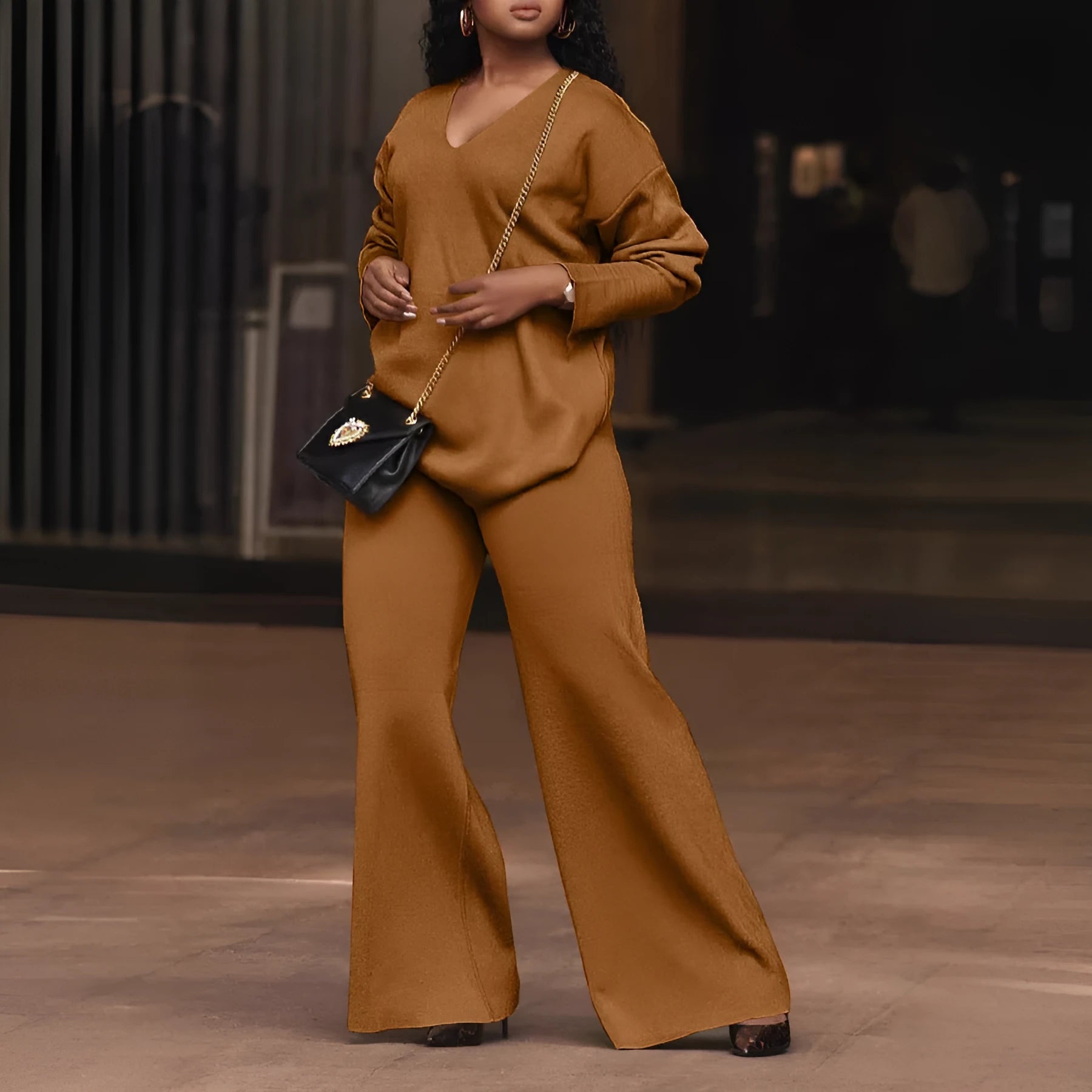 Women's brown suede two-piece suit with long sleeves and trousers on a hanger