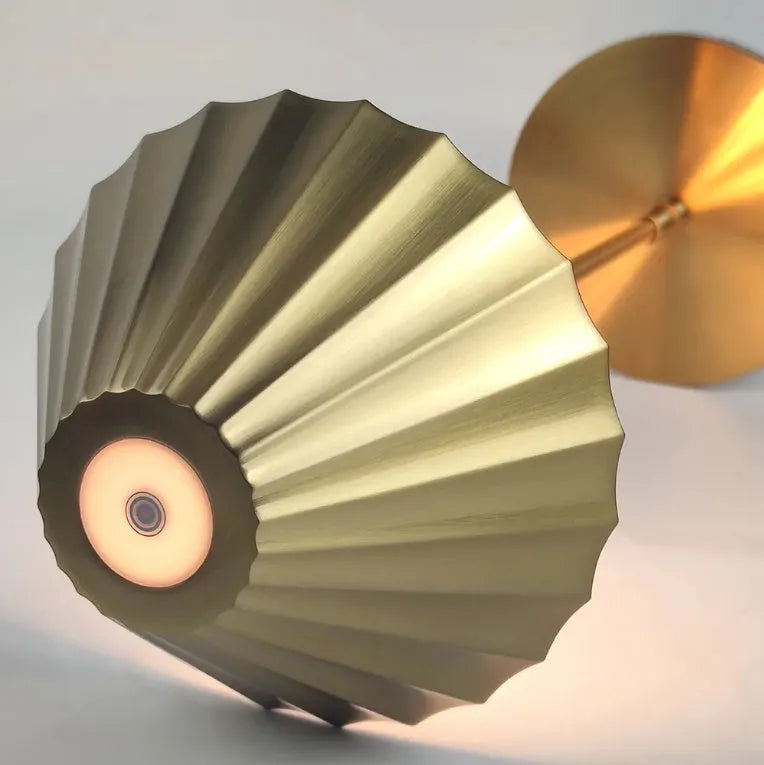 Gold alloy desk lamp with a fabric lampshade on a wooden table