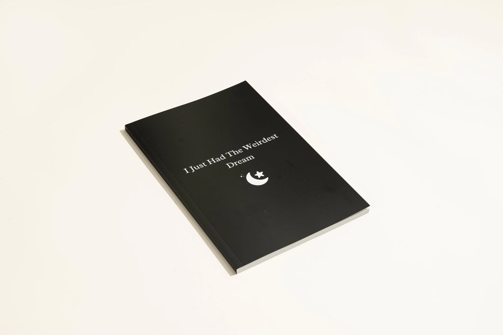 Black hardcover A5 dream journal notebook with lined pages showing business simplicity style