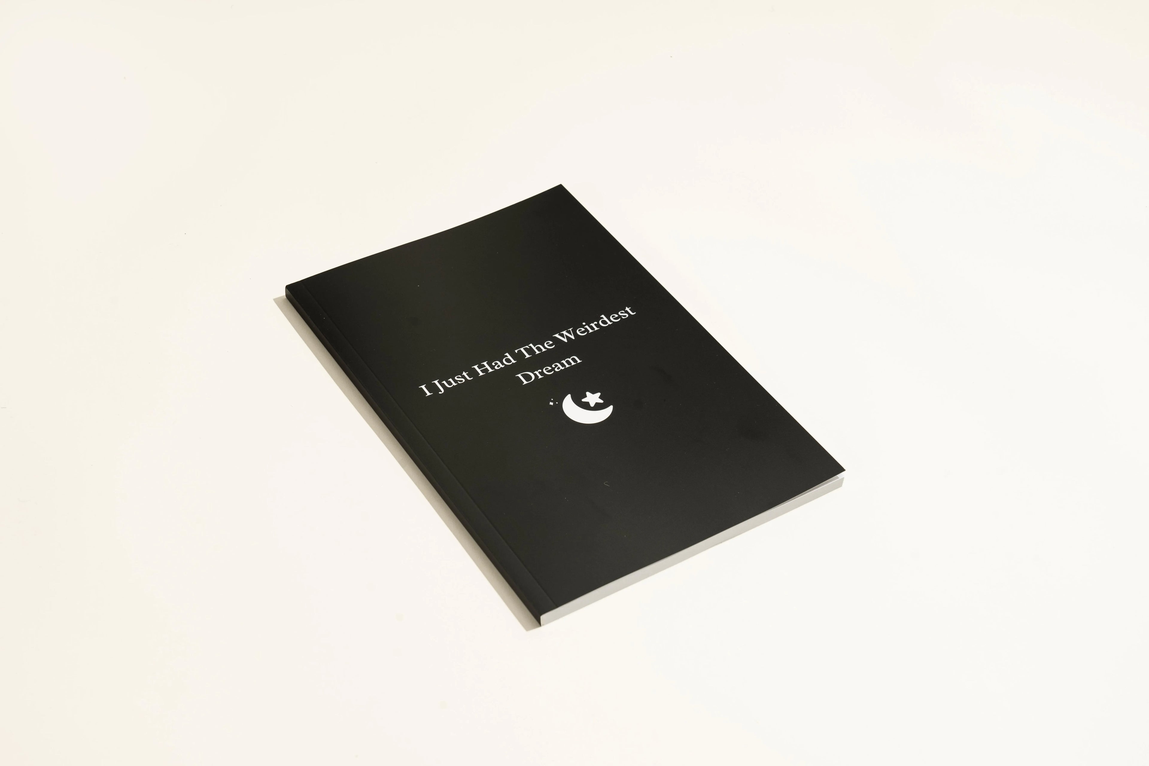 Black hardcover A5 dream journal notebook with lined pages showing business simplicity style