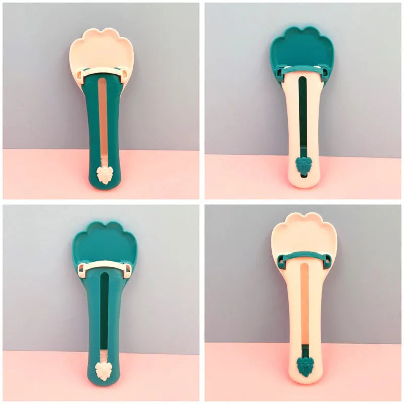 Green and pink handheld pet food squeezer spoon feeder for cats and dogs.