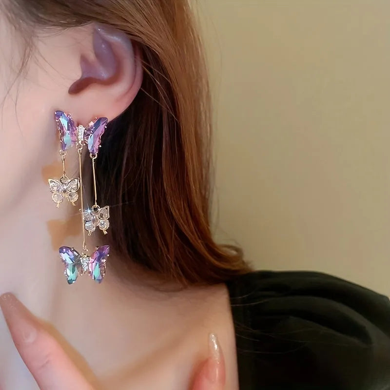 Blue purple butterfly earrings with crystal flowers and tassel details on silver needle posts