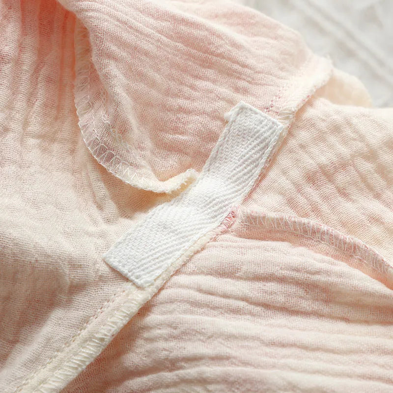 Women's pink cotton gauze long sleeve top and trousers lounge suit set on a hanger.