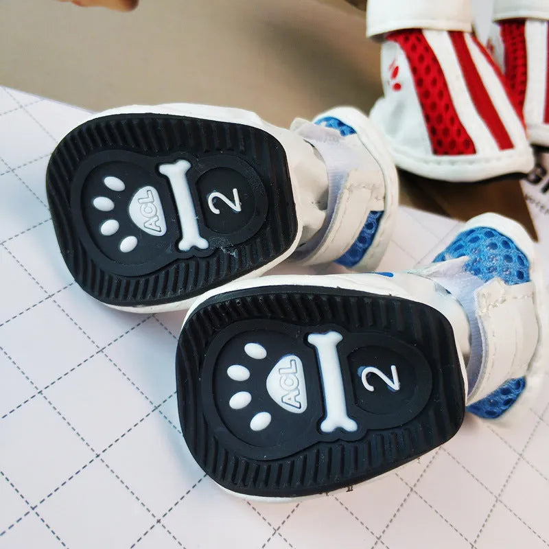 Set of four blue cloth dog sneakers with zip fasteners and non-slip soles laid out.