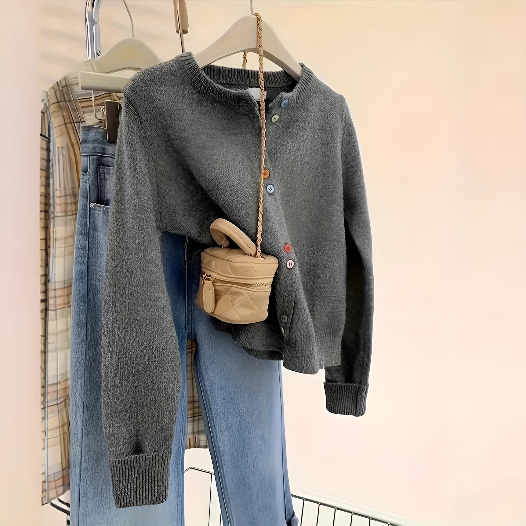 Dark grey women's polyester cardigan sweater with button front and long sleeves laid flat.