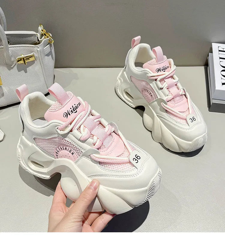 Women's pink sneakers with cross straps and thick sole showing side profile